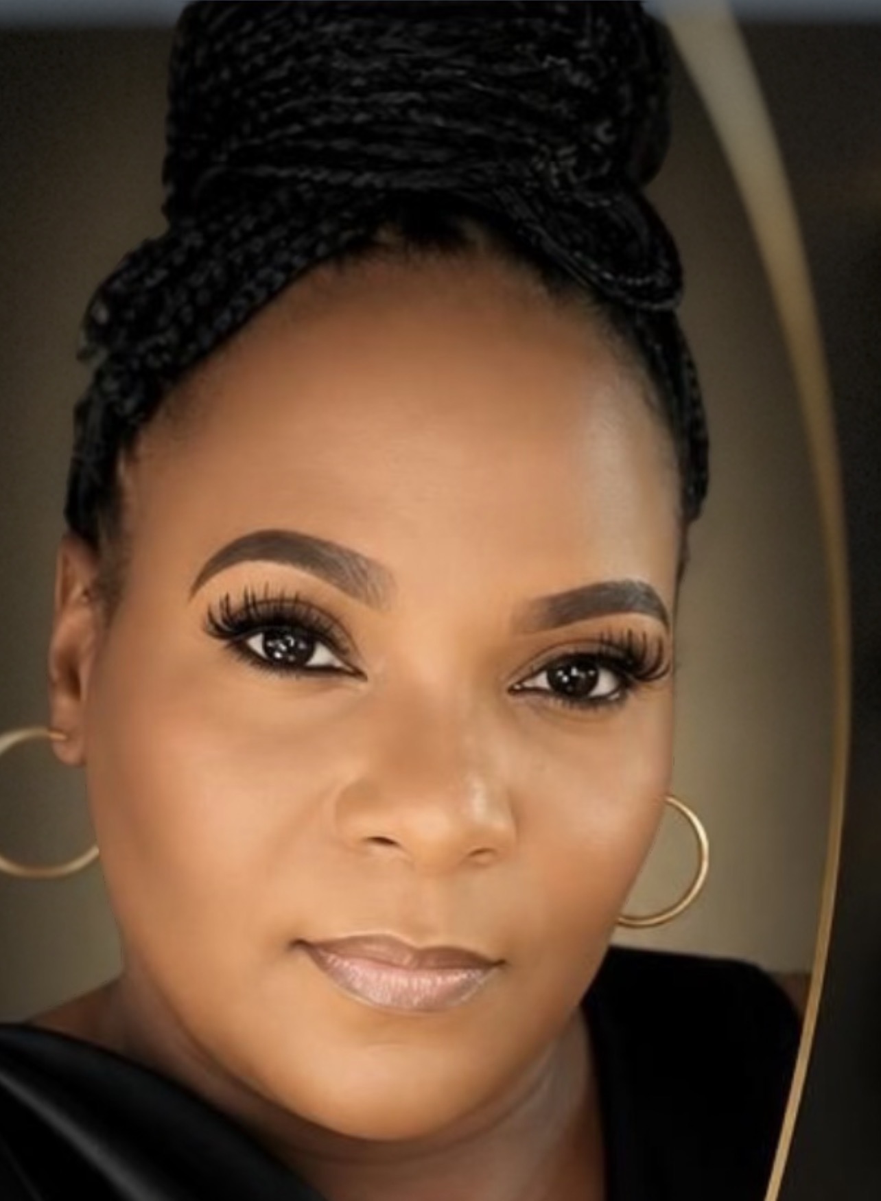 Dee Dillard, founder of BNspired, wearing a black-and-gold outfit with her braids in an updo.