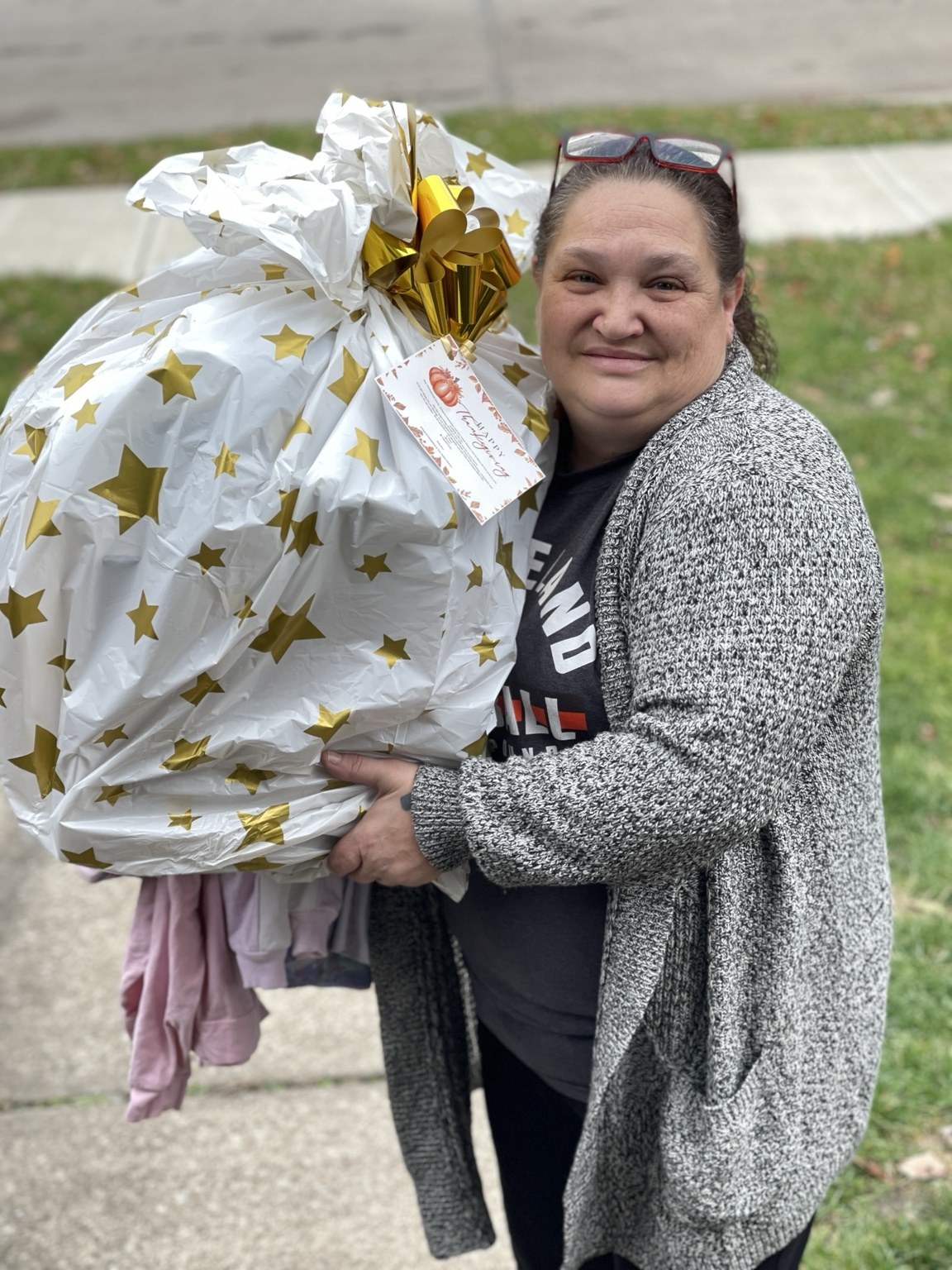 A community neighbor holding a wrapped holiday meal package.
